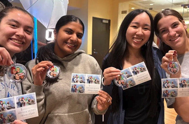 Students showing off photo booth prints and ornaments