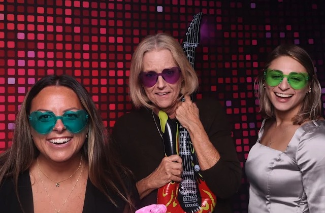 Friends with colorful sunglasses at neon photo booth