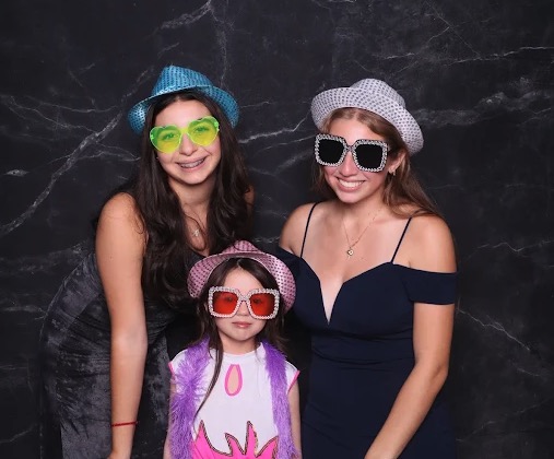 Family with fun hats and sunglasses at photo booth