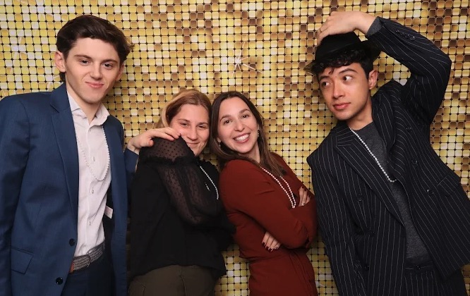 Friends posing at gold sequin wall photo booth