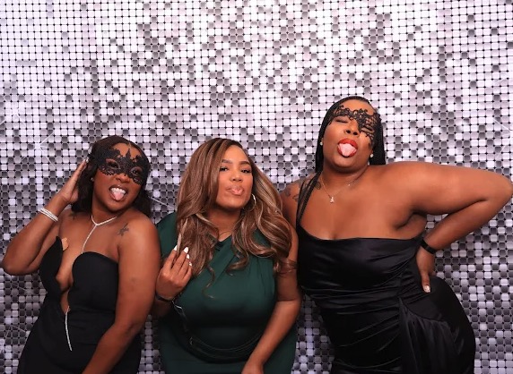 Friends posing at shimmer wall photo booth